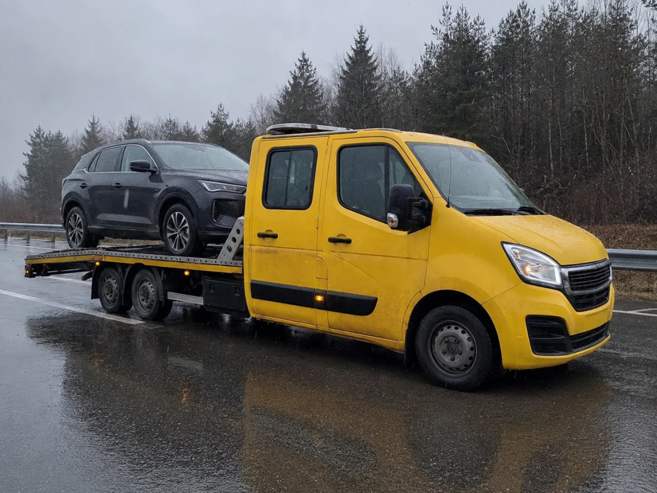 Holowanie srebrnego SUV-a na lawecie w deszczu – Zgierz